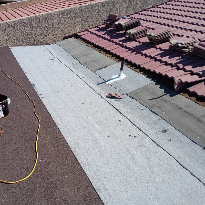 Flat roof tied into tile: New membrane run up to the tile edge, with the pipe flashing sealed.