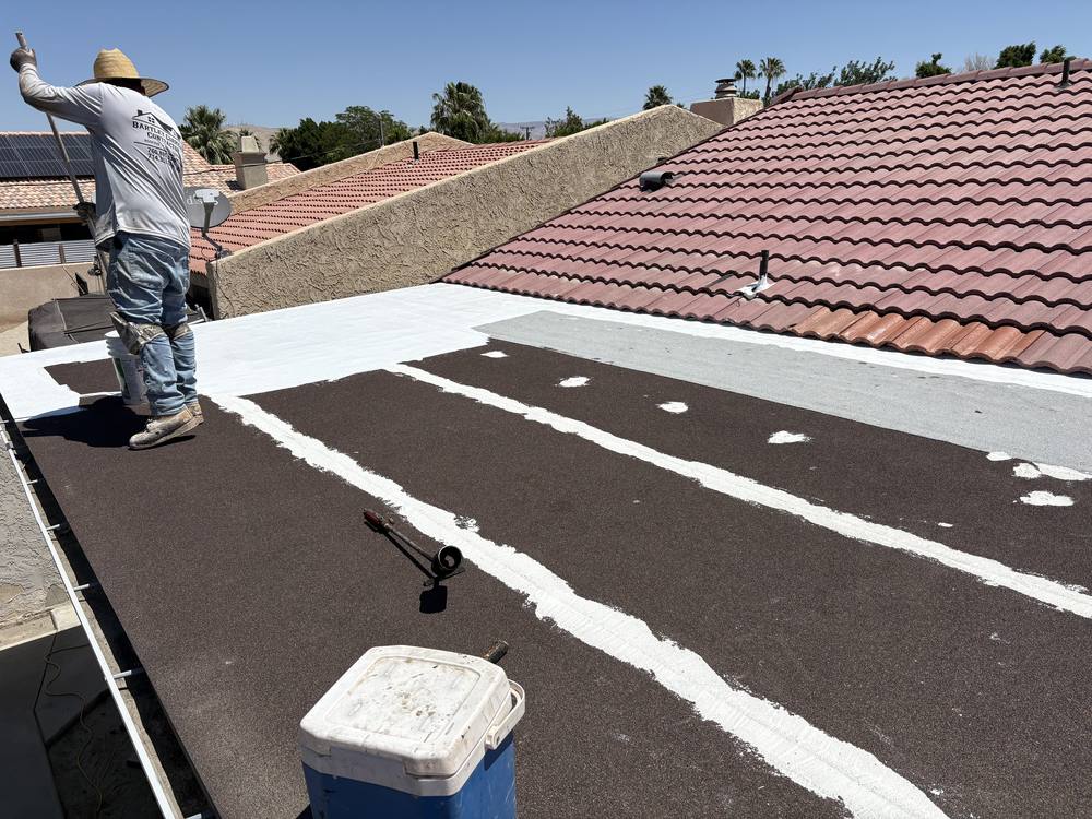 Crew sealing seams on a flat section between tile roofs
