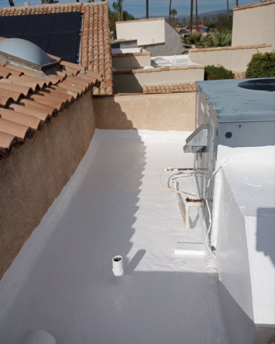 Coated roof deck walkway between tile and stucco walls